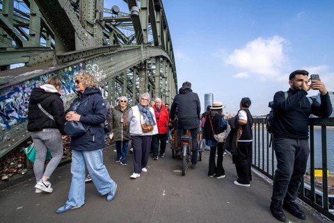 Cyclists and pedestrians get in each other's way, on the Hohenzollern Bridge, railway bridge over