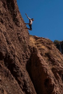 OUZOUD, MOROCCO - OCTOBER 5, 2024: A Moroccan young boy jumps from the high rock into the water