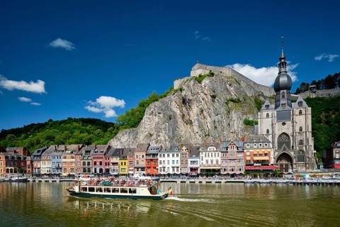 DINANT, BELIGUM, MAY 30, 2018: View of Dinant city over the Meuse river with tourist boat. Dinant