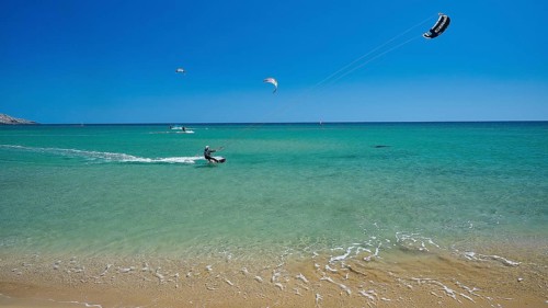Kitesurfer on turquoise sea near the calm beach under clear sky, surfers paradise, kitesurfer,