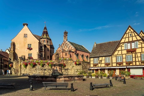 Fountain Fontaine de Saint-Léon and St Leo's Chapel in Eguisheim, Alsace, France