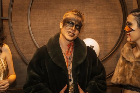 Halloween party with friends in a disco nightclub, portrait of a man in zombie makeup