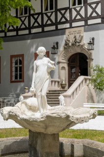 Female figure with water jugs on a shell, white fountain in front of Rauenstein Castle,