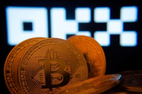 Dhaka, Bangladesh- 04 April 2025: Close-up of Bitcoin coins with the OKX logo visible on a screen