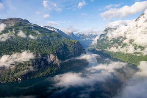 View over the Geirangerfjord, atmospheric clouds over the fjord in the morning light, Ørnesvingen