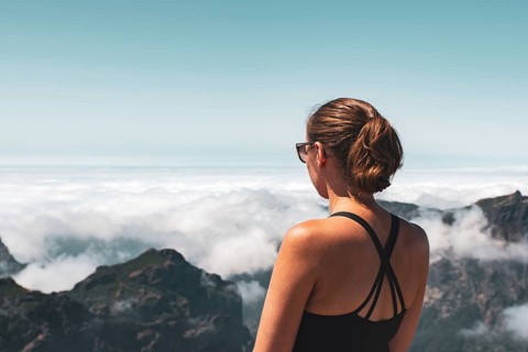 Woman looking from a mountain top over a cloud cover, peaceful atmosphere, Pico Ruivo, Madeira,