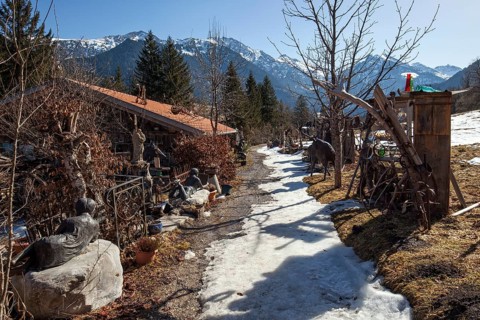 Hiking trail, carriage museum on the left, snow-covered mountains of the Allgäu Alps in the