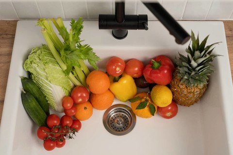 A variety of fresh fruits and vegetables, including tomatoes, oranges, and pineapple, placed in a