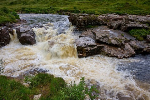 Rustling river flows over rocks in a green landscape, River Orchy, Bridge of Orchy, Scotland,