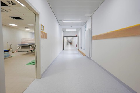 Long, bright corridor in a modern clinic with white walls and yellow handrail, new Calw Hospital,