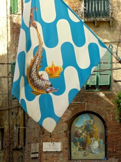 Il Palio di Siena, historical horse race, flags with dolphin of the Contrada Capitana dell Onda,