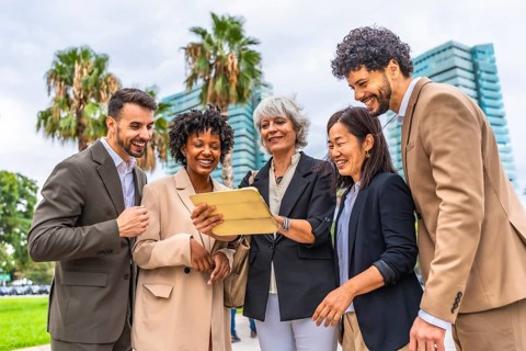Multi-ethnic colleagues using digital tablet during outdoor business meeting in a tropical modern