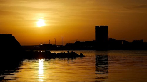 Sunrise, French Tower, over a quiet harbour with silhouettes and golden water, harbour area, Rhodes