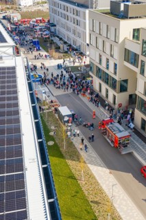 Aerial view of a street scene with fire department, crowds and modern buildings, hospital opening,