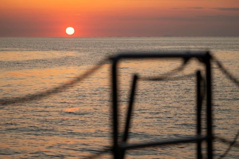View of sea and setting sun from a sailing ship, Strait of Messina, Calabria, Aeolian or Aeolian