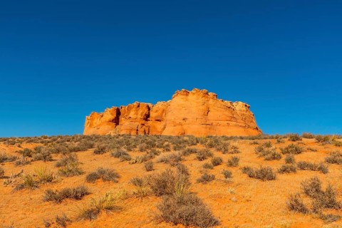 Scenic view of arid page, arizona, capturing the sunlit red rock formation and sprawling desert