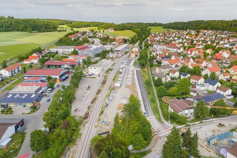 Small town seen from the air with railway tracks in the middle and surrounded by residential and