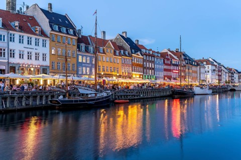 Colourful houses, restaurants and historic ships on the Nyhavn canal and harbour at dusk,