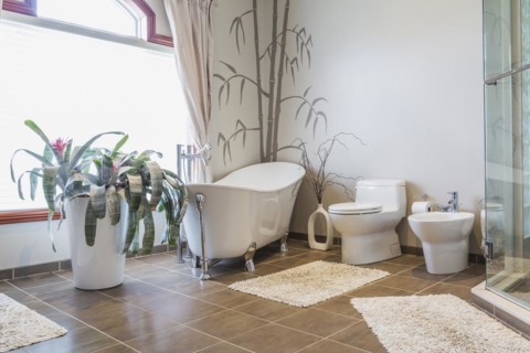 Freestanding bathtub, bidet, clear glass shower stall in en suite with grey nuanced ceramic tile