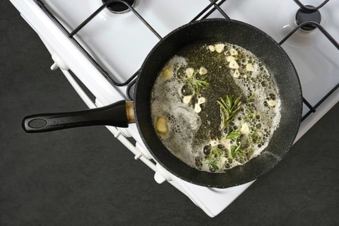 Infusing olive oil and melted butter with the flavour of fresh garlic and rosemary in a skillet