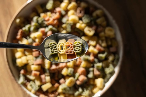 A spoon displaying 2026 in colorful number shaped pasta celebrates the upcoming new year, showcased