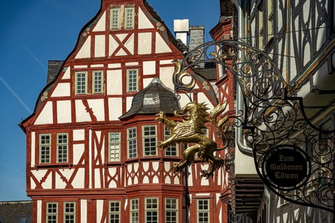Sign for the Golden Lion and timber-framed house in the old town of Limburg an der Lahn, Hesse,