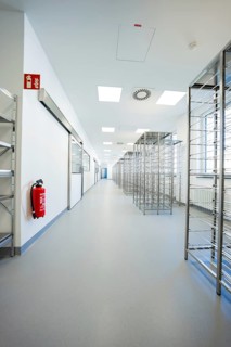 Bright corridor with metal shelves and a fire extinguisher under sterile conditions, operating room