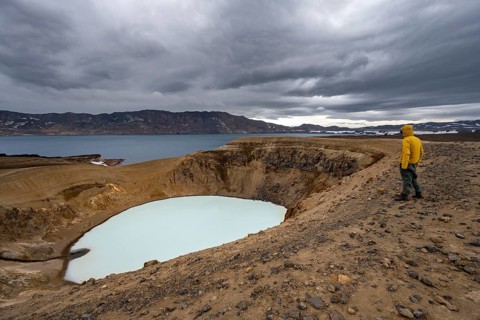 Tourist at the crater rim, crater lake Víti and Öskjuvatn in the crater of Askja volcano, volcanic