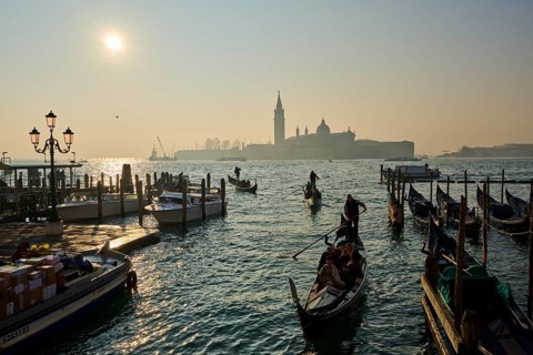 View from 'Ponte della Paglia' bridge on church 'Giorgio Maggiore' with gondolier in front on a