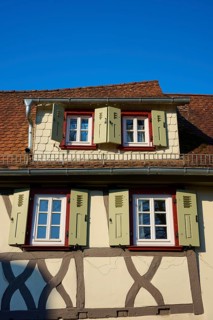 Timbered house with open green shutters under a clear blue sky, Erbach, Odenwald, South Hesse,