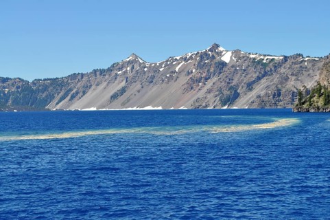 View of Crater Lake's deep blue water and snow-capped mountain peaks, Crater Lake National Park,