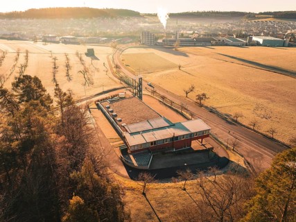 Building with surrounding fields and forest in golden morning light, Althengstett fire station,