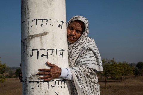 Man from the Ramnami community hugging the pillar of a Ramnami place of worship as a sign of