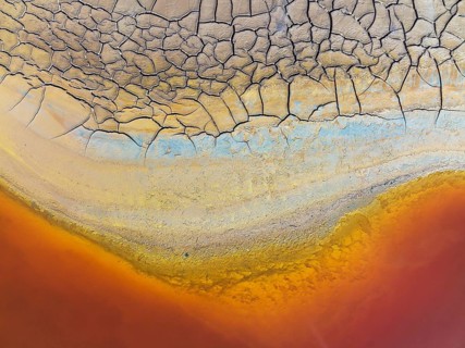 Cracked earth at the bank of the Rio Tinto (Red river) with its deep reddish hue due to oxidised