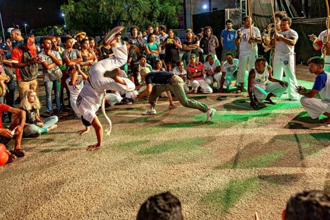Dynamic capoeira movements in the midst of an interested crowd, The Capoeira battle dance at a