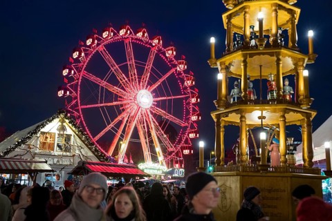 Ferris wheel behind a Christmas pyramid at the Christmas market on Alexanderplatz, Berlin, 21.12