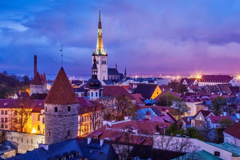 Aerial view of Tallinn Medieval Old Town illuminated in evening twilight, with dramatic sky Estonia
