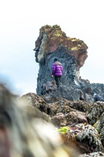 Adventurous young man on his back on Djupalonssandur beach in winter in Iceland