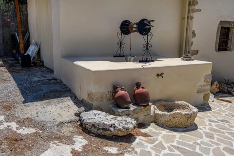 Old fountain in front of two clay jugs in Unesco Site Orthodox Greek Orthodox Monastery Moni