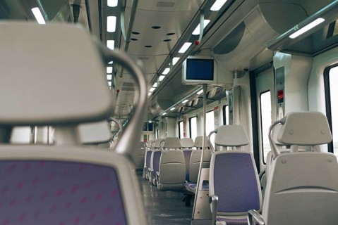 Discover the sleek interior of a modern train, featuring empty seats, soft ambient lighting, and