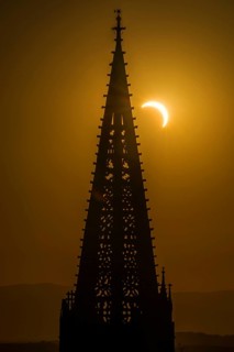 Partial solar eclipse August 2026 and the tower of Freiburg Minster, sunset, Freiburg im Breisgau,