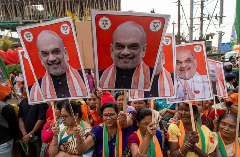 Supporters hold placards featuring Amit Shah during a public rally of the Bharatiya Janata Party