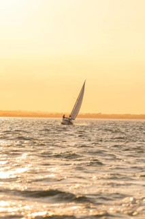 A sailboat at dawn, soft light and calm sea, Howth, Ireland