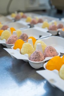 Colourful fluffy eggs in different colours in an egg carton in a kitchen, Easter baking and