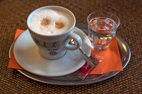 Cappuccino with a glass of water on a tray, Germany