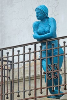 Sculpture by Nicole Brousse, blue woman on balcony railing, blue, standing, balcony railing, metal