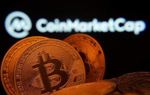 Dhaka, Bangladesh- 27 March 2025: Close-up of Bitcoin coins with the Coinmarketcap logo visible on