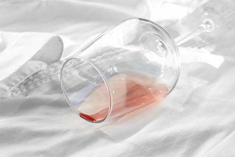 Glass, with pink wine, spilled on a white shirt, close-up, selective focus, no people, concept, top
