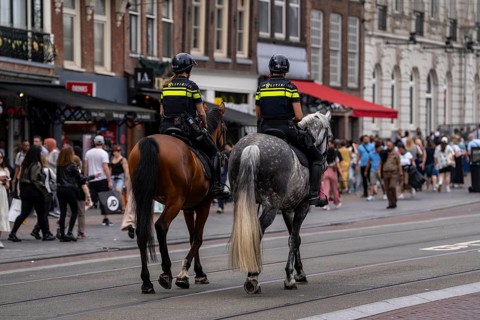 Mounted police patrol on Damrak shopping street, tourists, visitors, Amsterdam, Netherlands