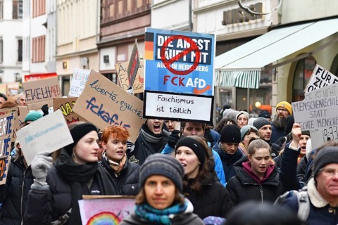 Heidelberg, Germany - February 12th 2025: People holding up signs in crowd at protest against
